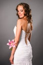 Back view of smiling young bride with a flower