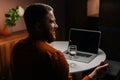 Back view of smiling young man making video call using laptop computer presenting ring and making remote marriage Royalty Free Stock Photo