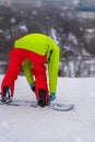 Back view of Snowboarder attaches Snowboard on ski slope. Winter sport and outdoor activities concept Royalty Free Stock Photo