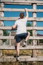 back view of soldier climbing wooden barrier during obstacle run Royalty Free Stock Photo