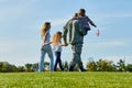 Back view soldier and his family are walking on the grass. Royalty Free Stock Photo