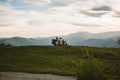 Back view of a Spanish man and a dog admiring nature while sitting on a camper van parked on a hill Royalty Free Stock Photo