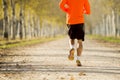 Back view sport man with strong calves muscle running outdoors in off road trail ground in Autumn sunlight