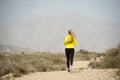 Back view sport runner girl training on earth trail dirty road desert mountain landscape Royalty Free Stock Photo