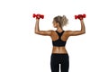 Back view of sportive woman doing physical exercises with red dumbbells isolated on white background Royalty Free Stock Photo