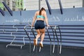 Rear view of sportswoman doing push-ups on uneven bars outdoors Royalty Free Stock Photo