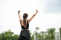 Back view, A sporty, carefree, and happy Asian woman raises her hands and rests after a long run Royalty Free Stock Photo