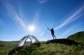 Silhouette of woman climber near camping against blue sky in the morning