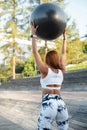 Back view of sporty young woman exercising with fitness ball in the park Royalty Free Stock Photo