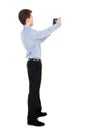 Back view of standing business man photographing a phone or tabl Royalty Free Stock Photo