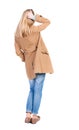 Back view of standing young beautiful blonde woman in brown clo Royalty Free Stock Photo