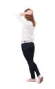 Back view of standing young beautiful blonde woman in jeans. Royalty Free Stock Photo