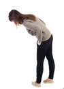 Back view of standing young beautiful woman in jeans looks down Royalty Free Stock Photo