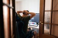 Back view of stressed programmer sitting in gaming chair in home office, holding head in hands after unsuccessful coding Royalty Free Stock Photo
