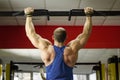 Back view of strong male athlete with perfect muscles training, doing exercises