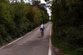 Back view of strong male cyclist riding bike at the paved road Royalty Free Stock Photo