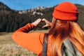 Back view of stylish Woman in red hat with backpack hiking in woods. Freedom and active lifestyle concept. Adventure Royalty Free Stock Photo