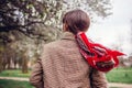 Back view of stylish woman wearing red hair scarf in spring park. Retro female fashion. Headscarf for bun hairstyle Royalty Free Stock Photo