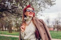 Back view of stylish woman wearing red hair scarf in spring park. Retro female fashion. Headscarf for bun hairstyle Royalty Free Stock Photo