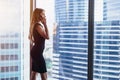 Back view of successful businesswoman having phone conversation looking out the window with cityscape view Royalty Free Stock Photo