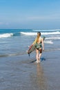 back view of surfer in swimsuit walking with surfboard on beach Royalty Free Stock Photo