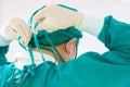 Back view of surgeon tying surgical cap in preparation, Medical team performing surgical operation in operating room, Team surgeon Royalty Free Stock Photo