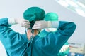 Back view of surgeon tying surgical cap in preparation, Medical team performing surgical operation in operating room, Team surgeon Royalty Free Stock Photo