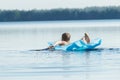 Back view of teenager paddling with his arms and floating on blue pool lilo outdoors Royalty Free Stock Photo