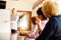 Back view of three elderly women sitting at desk, making notes, listening to lecturer. Speaker explaining strategy. Royalty Free Stock Photo