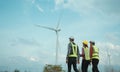 Back view of three engineers discussing and progress check wind turbine field