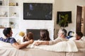 Back view of three generation Hispanic family on the sofa watching TV, grandad looking at adult son Royalty Free Stock Photo