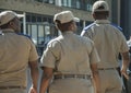 Back view of three south african traffic officers, one female and two males, wearing caps