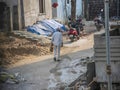 Back view of 60 to 70 aged Indian Man wearing white color checks shirt and light gray color walking toward his home.