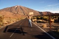 Back view of topless woman walking alone on the empty street in the middle of volcanic landscape, with protest banner Royalty Free Stock Photo