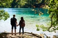 Back view of tourist couple boy and girl with backpacks standing on river bank Royalty Free Stock Photo