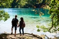 Back view of tourist couple boy and girl with backpacks standing on river bank Royalty Free Stock Photo