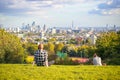 Tourists looking over London city skyline from Parliament Hill in Hampstead Heath