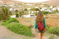 Back view traveler backpacker woman walking on Fuerteventura pathway to Betancuria small colonial town, Spain