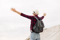 Back view, traveler man , raising his hands up on the trail on the top of the mountain, Tourist on top of high rocks Royalty Free Stock Photo