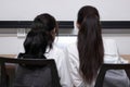 Back view of two attractive young Asian businesswoman using laptop together in modern office. Team work business concept Royalty Free Stock Photo