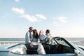 Back view of two couples standing and hugging near car Royalty Free Stock Photo
