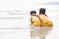 Back view of two cute asian little child girls hugging on beach Royalty Free Stock Photo