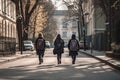 Back view of two girls with backpacks walking on the street in the early morning, University students with laptop bags on their