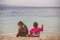 Back view of two little girls sitting near the sea Royalty Free Stock Photo