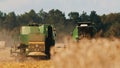 Back view of two modern combine harvester in a golden wheat field - Concept Of Agriculture