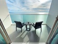 Back view of Two modern rattan armchairs, ashtray on table with sea view under blue sky. view from travel balcony. Summer vacation Royalty Free Stock Photo