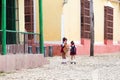 Back view of two small girls in school uniform walking home in old Trinidad