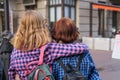 Back view of trendy teen girl friends hugging. Back view of two affectionate young students girls walking at street.