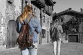 Back view of two women walking in old medieval village.Creative black and white photo with selective effect color in duplicated
