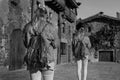 Back view of two women walking in old medieval village.Duplicated model, clone young girl in Rupit, Barcelona, Spain.Creative